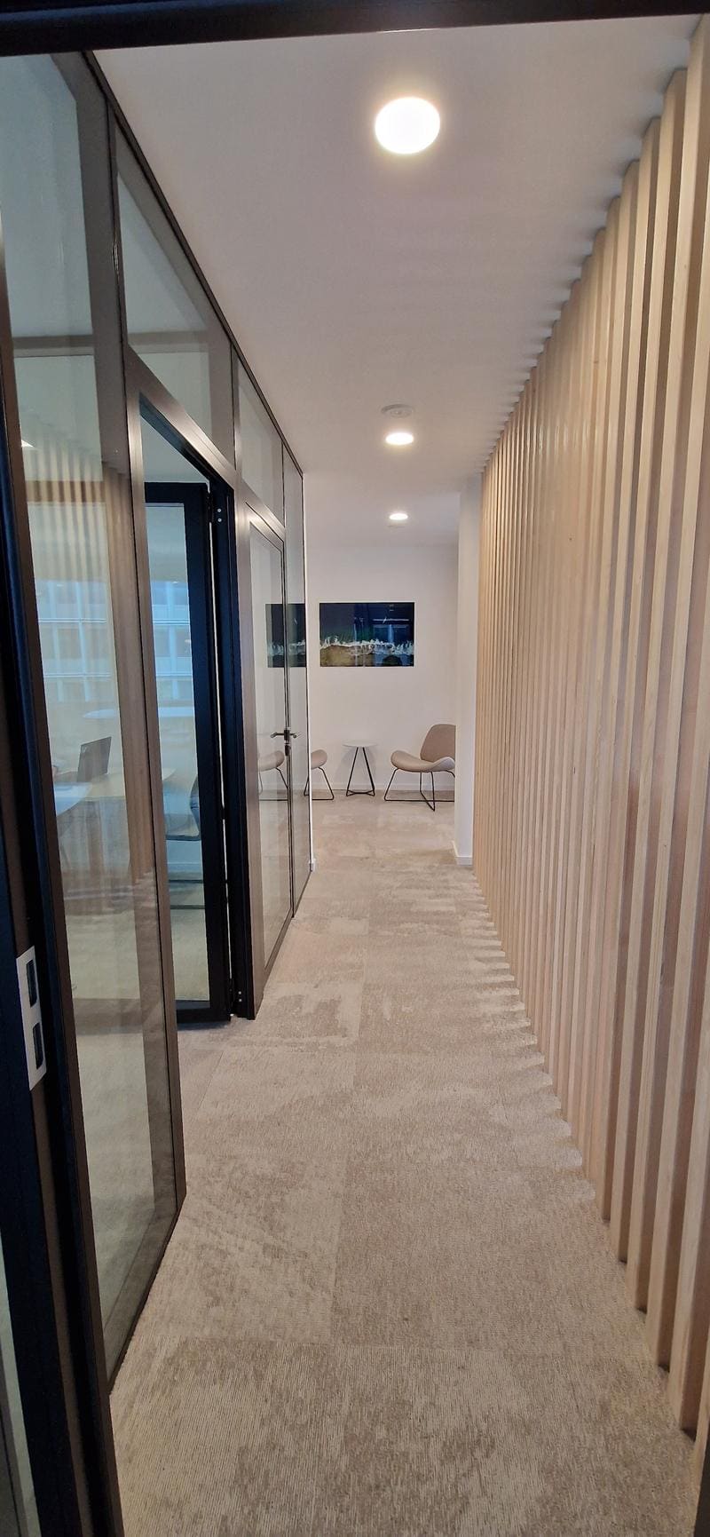 Vue depuis le couloir vers la réception — lames de bois, photo marine, fauteuils, Bd Helvétique Genève 2023
