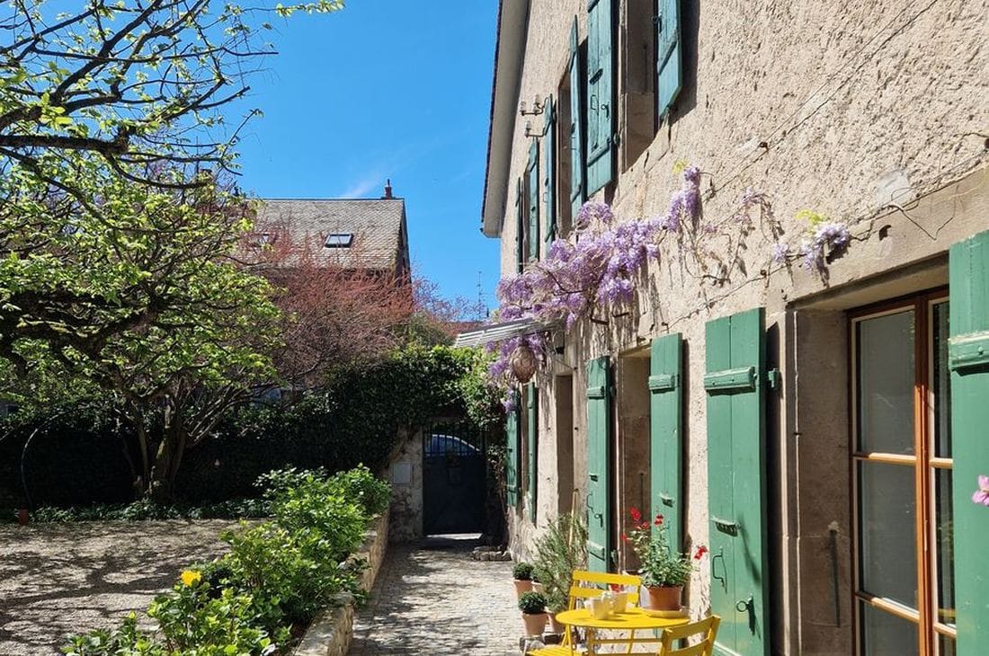 Maison de village rénovée Genève — cour pavée, glycine, volets verts